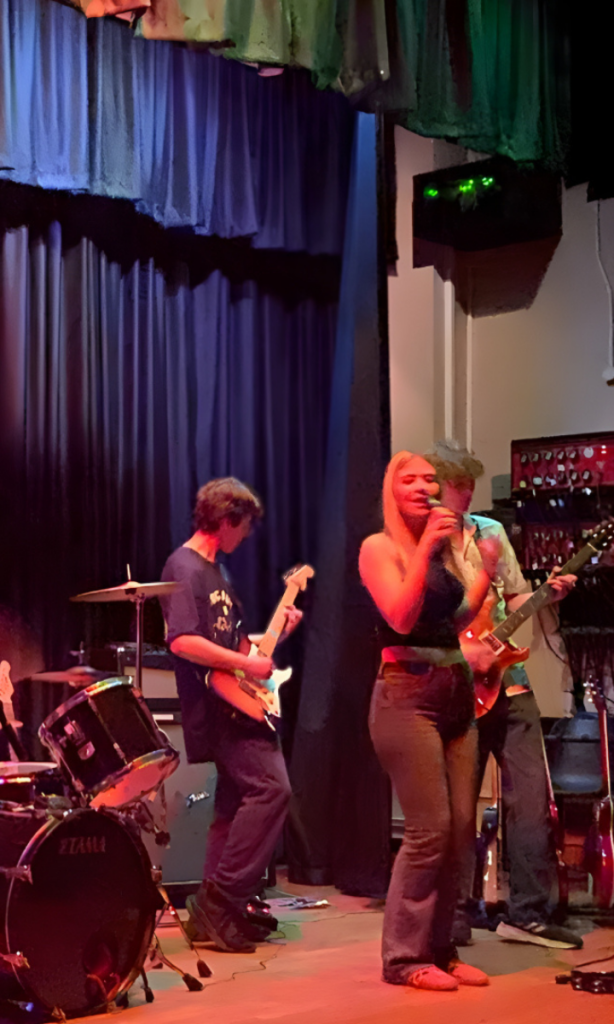 Students performing a rock song on the school stage