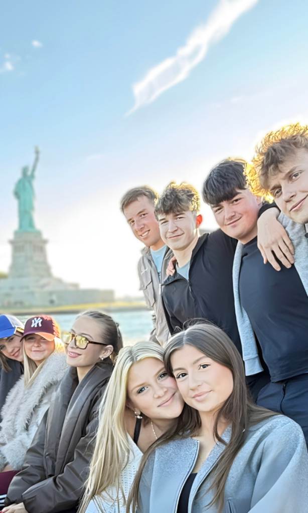 Sixth form students on a ferry, with the Statue of Liberty in the background