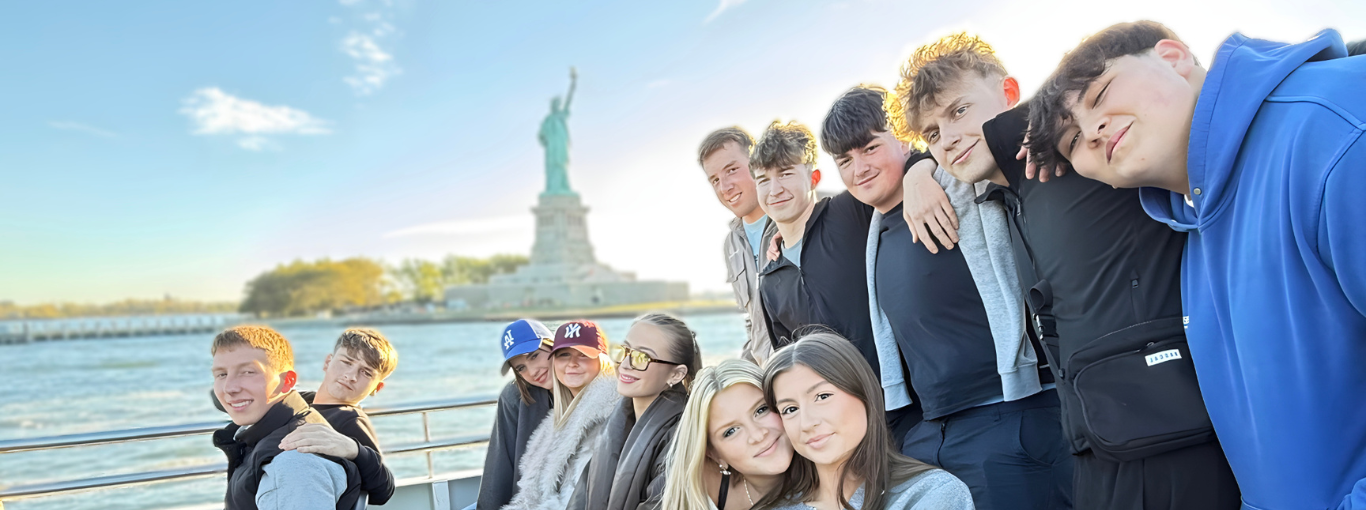 Sixth form students on a ferry, with the Statue of Liberty in the background