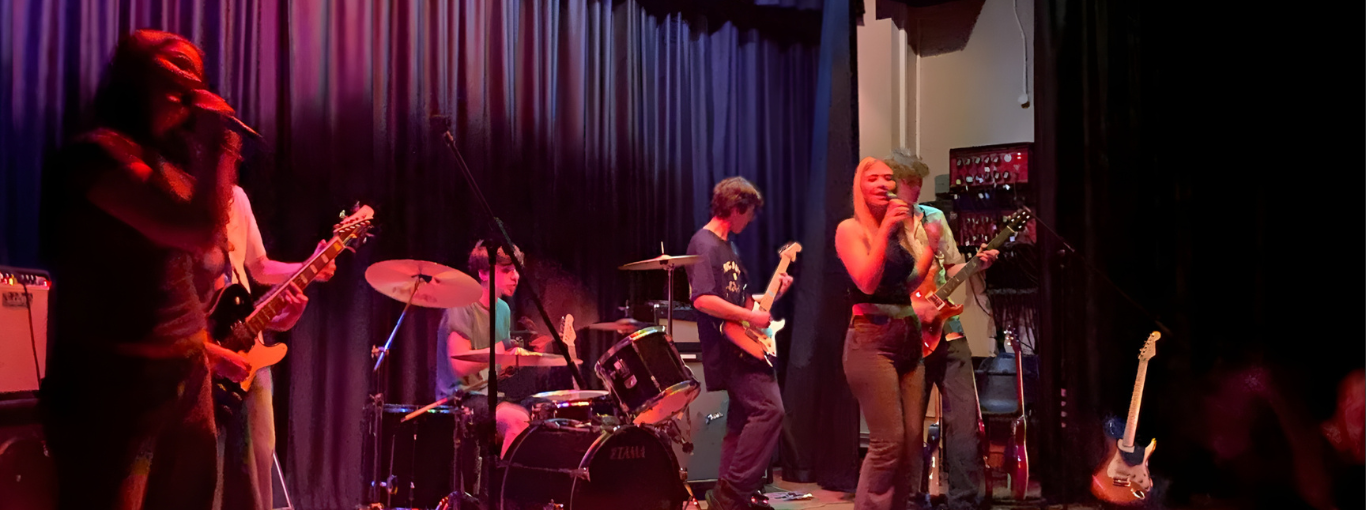Students performing a rock song on the school stage