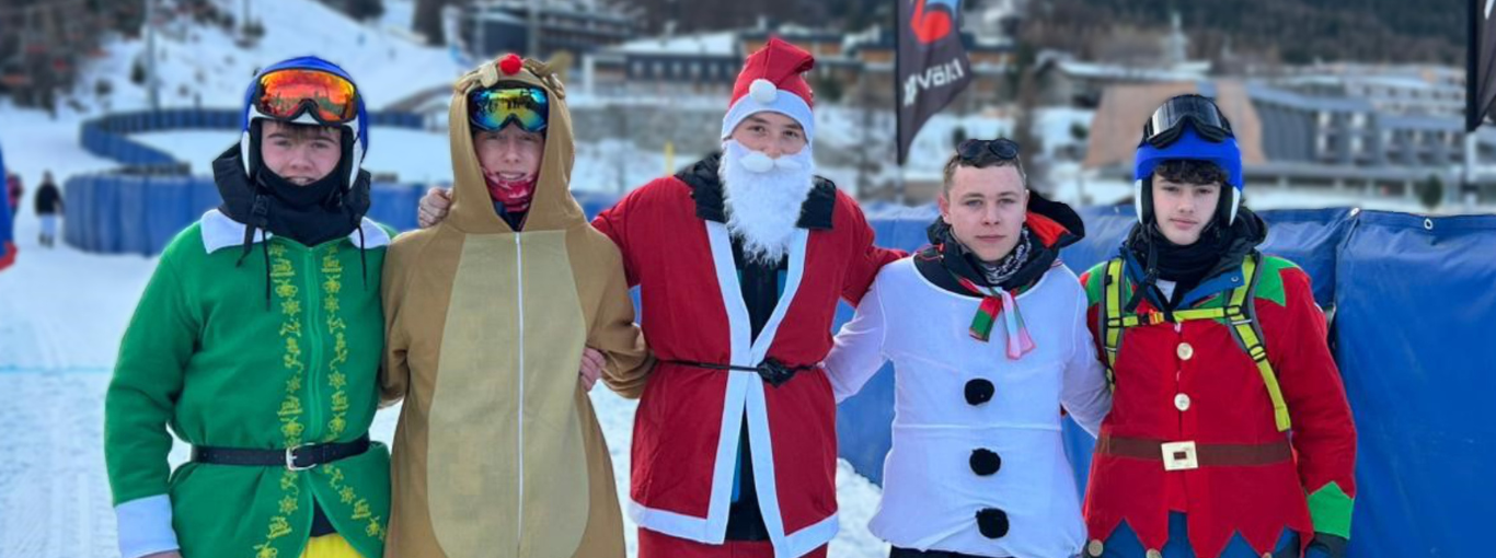 Students on a ski slope, dressed in costumes